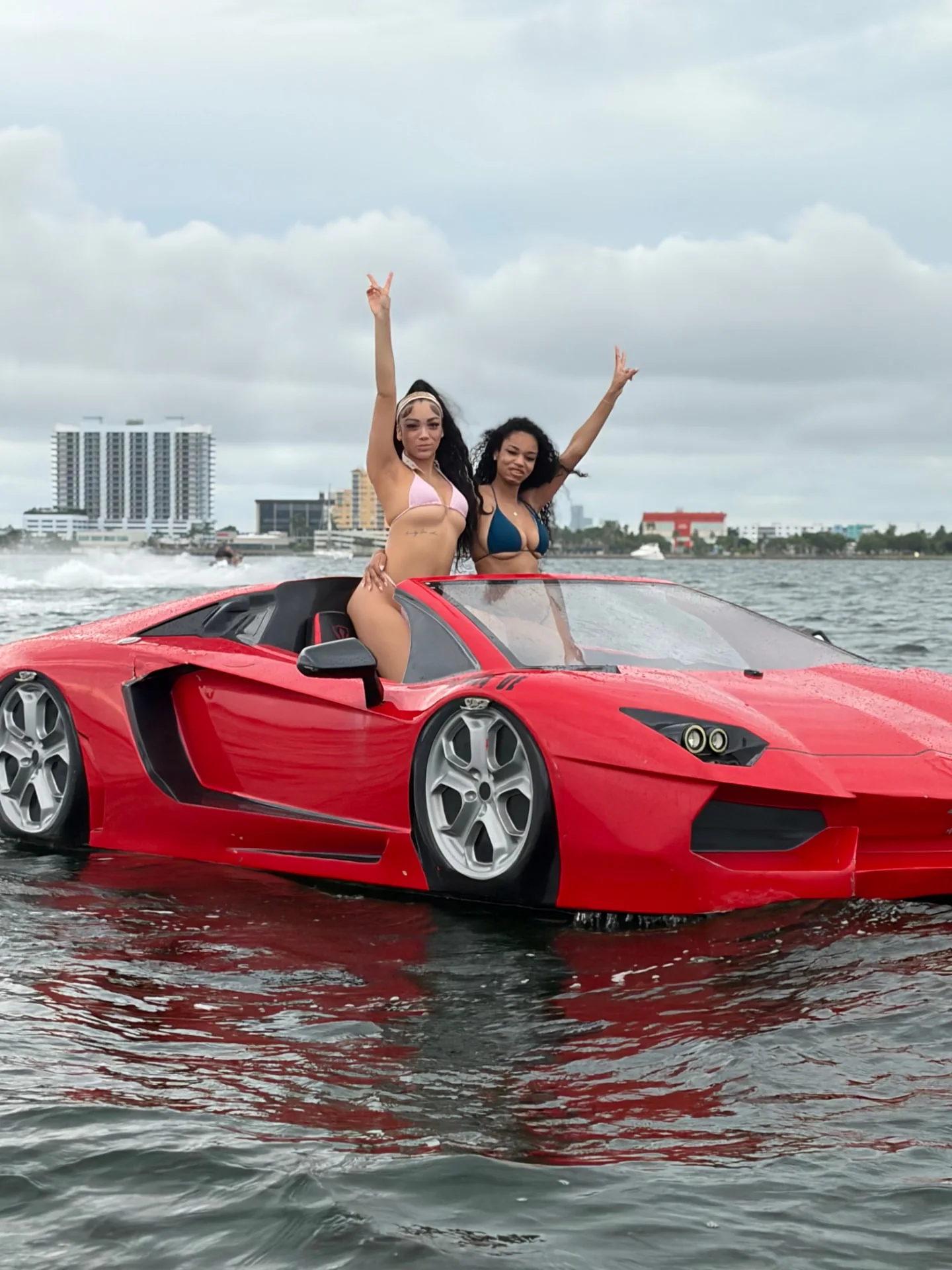 Two guests celebrating aboard a red Jetcar on the water