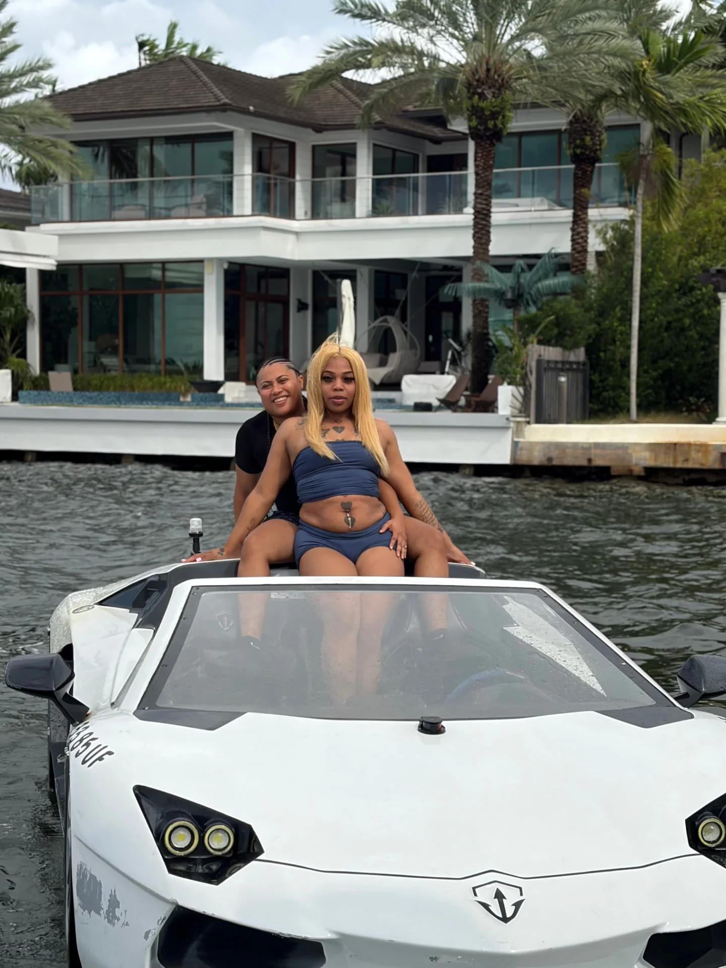 Guests seated in a white Jetcar near a palm-lined Miami waterfront