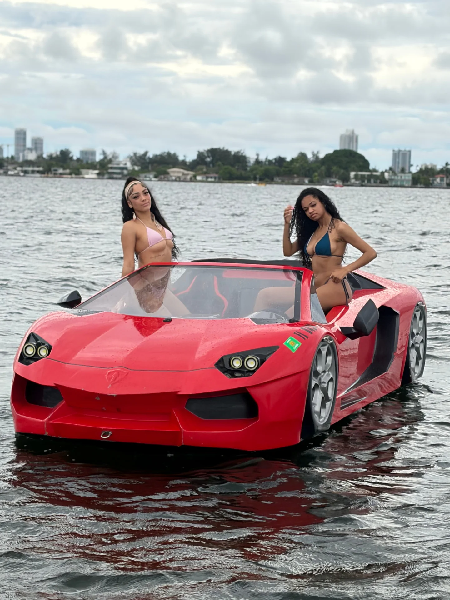 Guests beside a red Jetcar with the Miami skyline in the distance