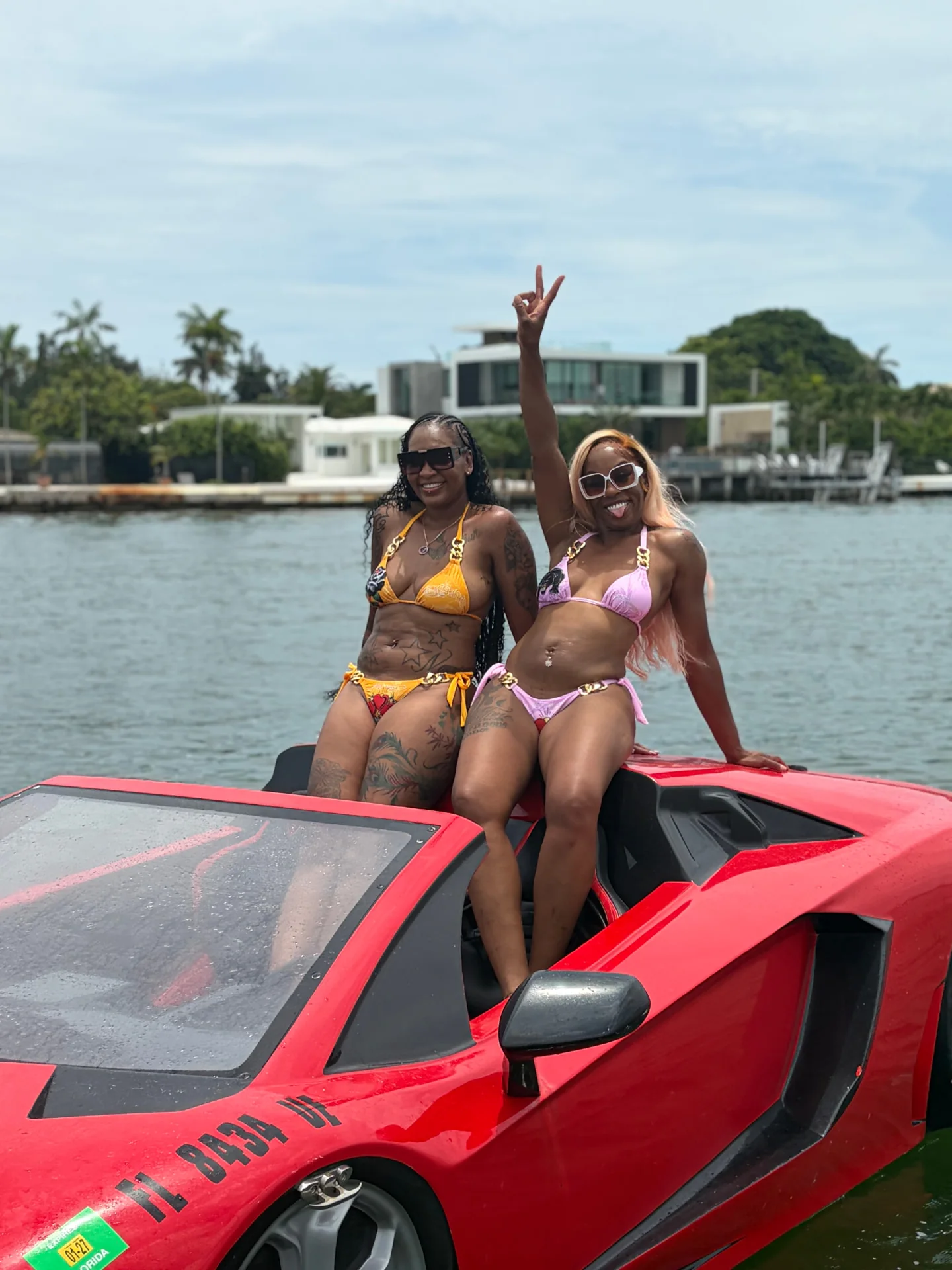 Two Maka Fun Rentals guests posing on a red Jetcar in Miami