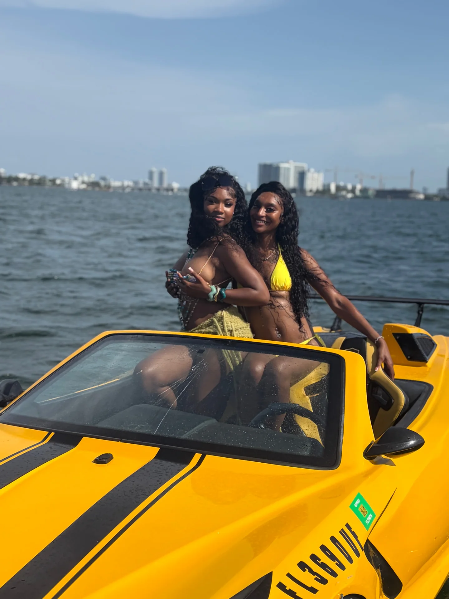 Two guests posing on a yellow Jetcar along the Miami waterfront